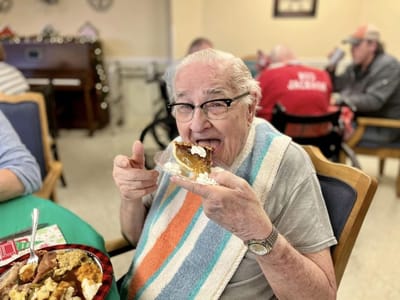 Resident enjoying dessert in a festive dining area