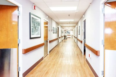 Bright corridor with wooden flooring and framed pictures