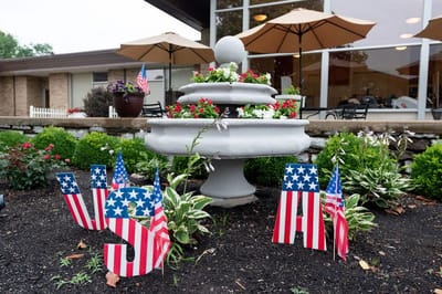 Fountain surrounded by flowers and flags