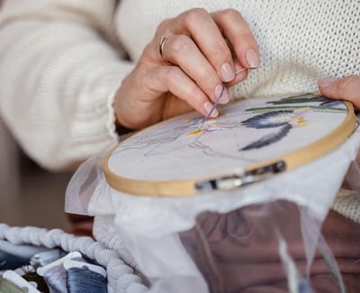 Close-up of a resident embroidering a floral design
