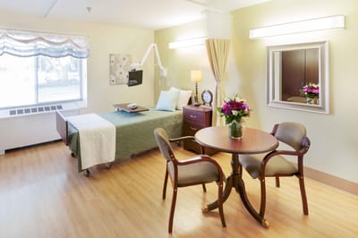 Bright private resident room with bed and table