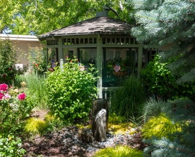 Gazebo surrounded by lush greenery and flowers