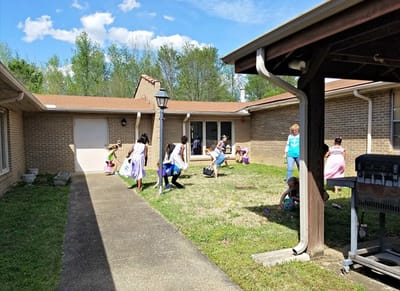 Children and staff participating in outdoor activities in a courtyard