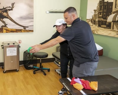 Staff assisting a resident with therapy exercises