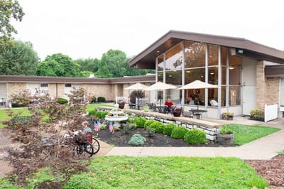 Exterior view of a senior living facility with outdoor seating