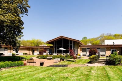 Exterior view of a senior living facility with seating area