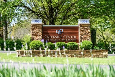 Sign for Creekside Center surrounded by greenery