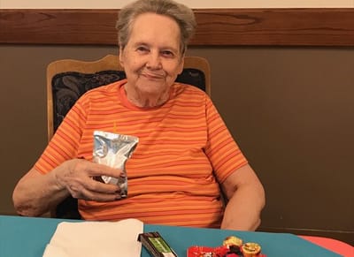 Senior resident enjoying a snack with a drink