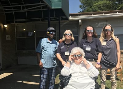 Residents and staff wearing sunglasses outdoors
