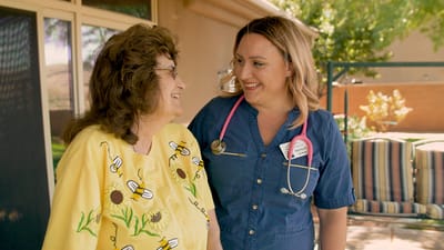 A caregiver and resident smiling outdoors
