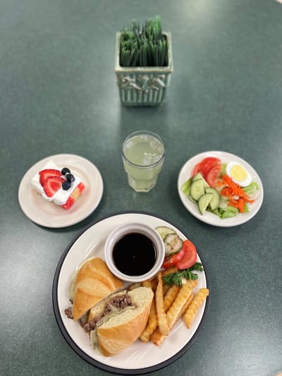 Plated meal with sandwich, fries, and salad