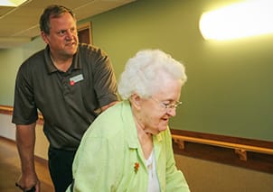American Lutheran Home-Mondovi, Nursing Home in Mondovi, WI — Caregiver assisting an elderly woman in a hallway