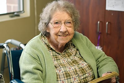 American Lutheran Home-Mondovi, Nursing Home in Mondovi, WI — Smiling resident in a wheelchair wearing a green sweater