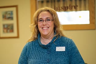 American Lutheran Home-Mondovi, Nursing Home in Mondovi, WI — Smiling staff member in a cozy setting