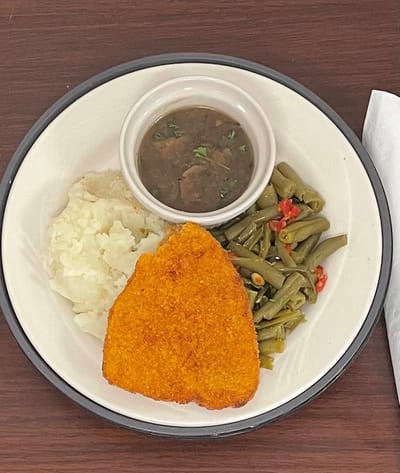 A plated meal with fish, mashed potatoes, and green beans