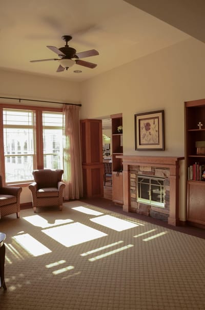 Bright common area with chairs and a fireplace
