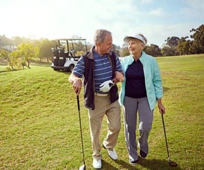 Happy seniors enjoying a day of golf outdoors