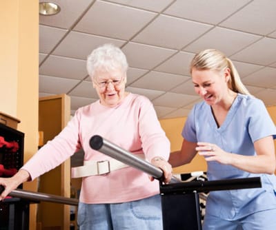 Resident participating in physical therapy with a staff member