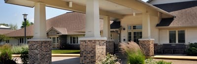 Covered entrance of a senior living facility with landscaping
