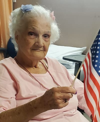 Senior resident holding a small American flag
