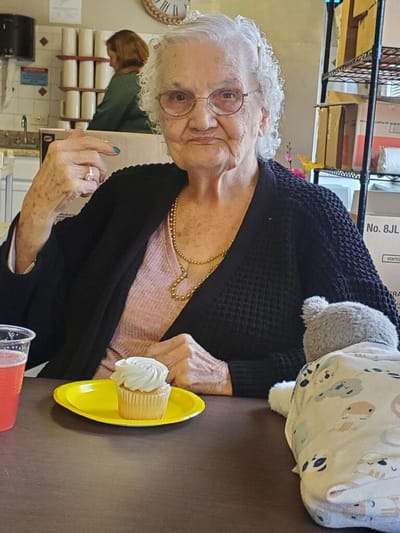 Senior woman enjoying a cupcake in a dining area