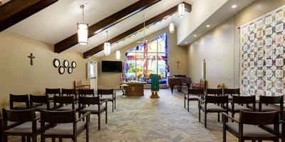 Interior view of a chapel with colorful stained glass