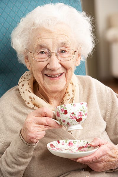 Meadowbrook Senior Living at Black River Falls, nursing home in Black River Falls, WI — Smiling elderly woman holding a teacup and saucer