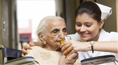 Meadowbrook Senior Living at Black River Falls, nursing home in Black River Falls, WI — Caregiver assisting elderly woman with a drink