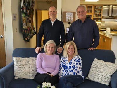 Residents and staff smiling together on a couch