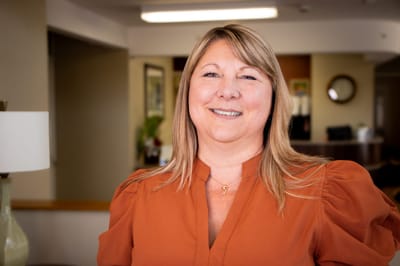 Staff member smiling in a bright facility lobby