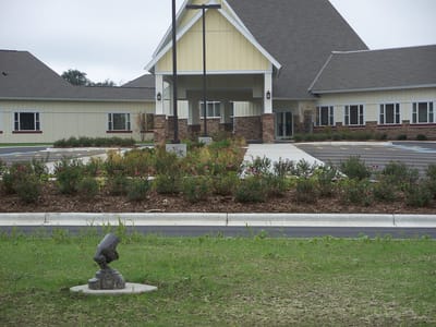 Front entrance of a senior living facility with landscaped garden