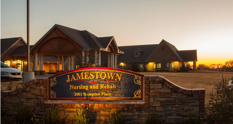 Exterior view of nursing home with signage at sunset