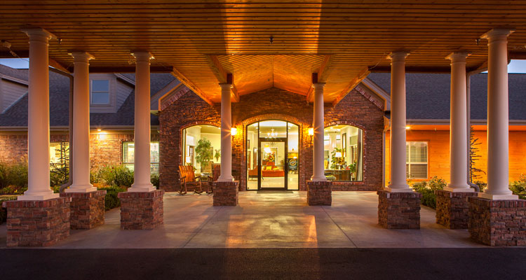 Entrance of a senior living facility under a wooden canopy