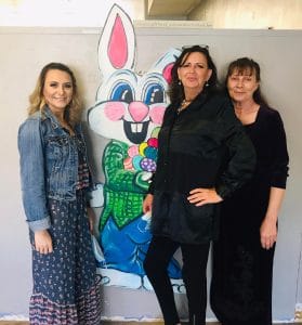 Piggott Healthcare & Senior Living, Nursing Home in Piggott, AR — Three women posing beside a colorful rabbit mural