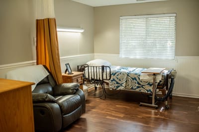 Cozy private room with a bed and chair
