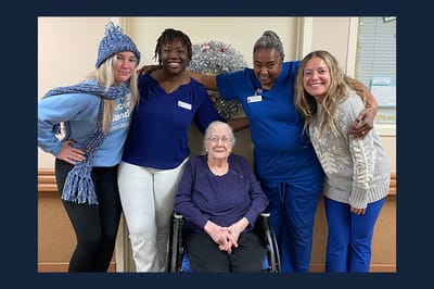 Staff and a resident celebrating with smiles