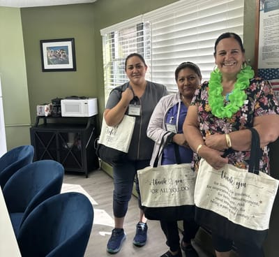 Staff members smiling with appreciation bags in a common area