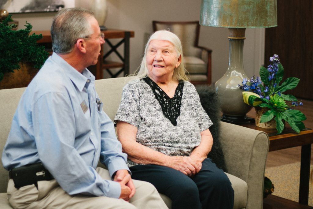 A happy resident and staff member conversing in a common area