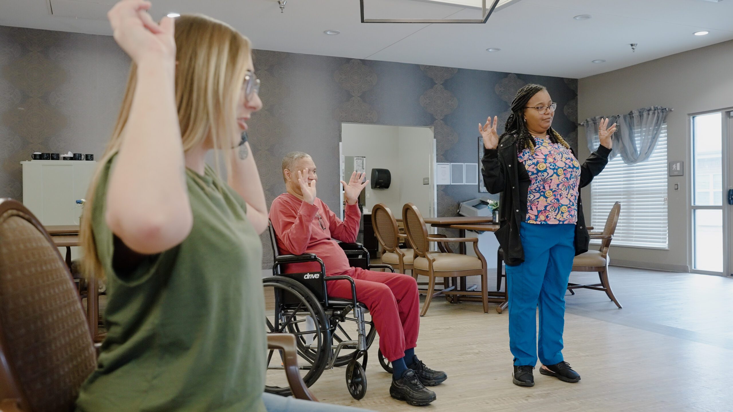 Residents participating in a seated exercise class with staff