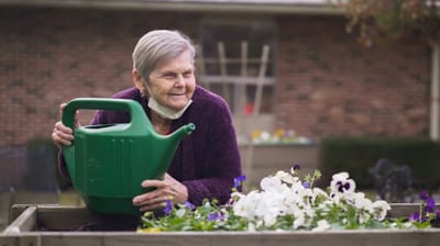 Resident watering flowers in a garden