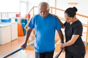 Fort Valley Health and Rehab, Nursing Home in Fort Valley, GA — Senior man assisted during rehabilitation exercises
