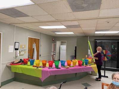 Staff member preparing for a celebration with colorful buckets
