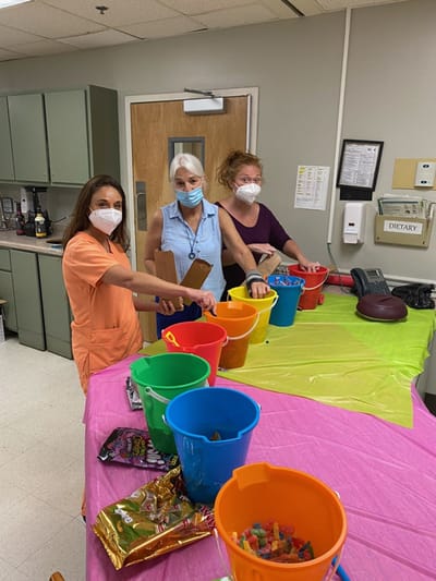 Staff engaging residents with colorful activity bins