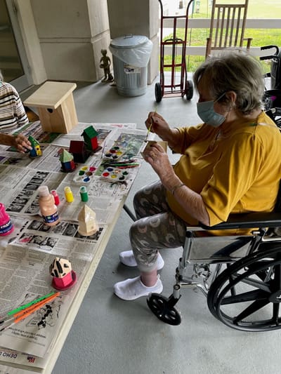 Resident crafting colorful birdhouses outdoors
