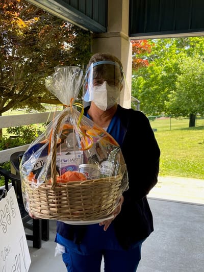 Staff member holding a gift basket outdoors
