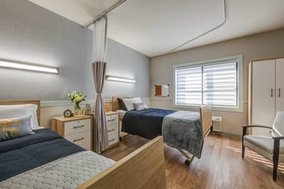 Bright resident room with two beds and modern furnishings