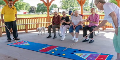 Residents engaging in a game outside under a shelter