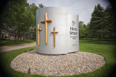 Sign for Holy Spirit Retirement Home surrounded by greenery