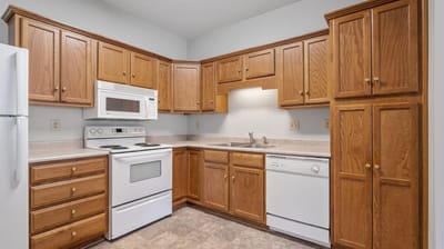 A well-lit kitchen with wooden cabinets and appliances