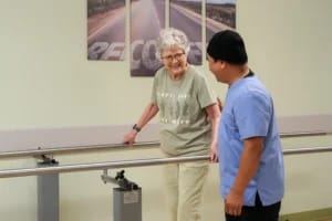 Mason Health Care Center, Nursing Home in Warsaw, IN — Senior resident using parallel bars with caregiver assistance